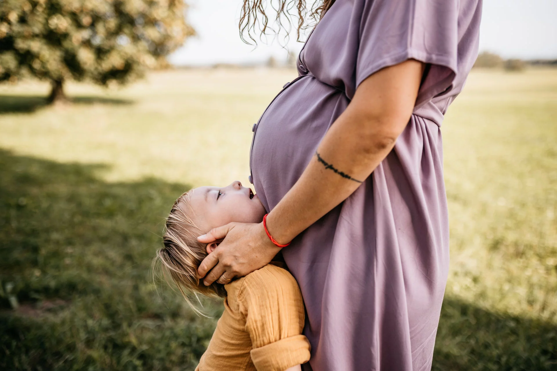 Babybauch Fotografie Oberbayern – werdende Mutter im goldenen Abendlicht